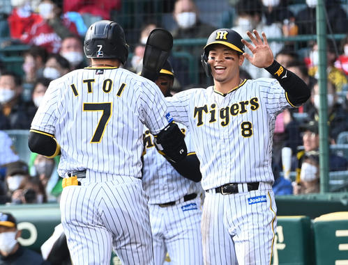 阪神対楽天　4回裏阪神1死二塁、バックスクリーンに2点本塁打を放った糸井（左）を笑顔で迎える佐藤輝（撮影・前岡正明）