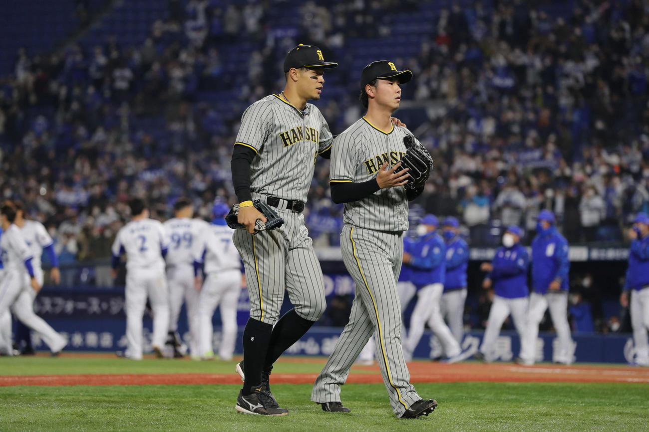 DeNA対阪神　10回裏DeNA無死、ソトに右越えサヨナラ本塁打を浴び、喜ぶDeNAナインを背に引き揚げる阪神浜地。左は肩に手をやり声をかける佐藤輝（撮影・前田充）