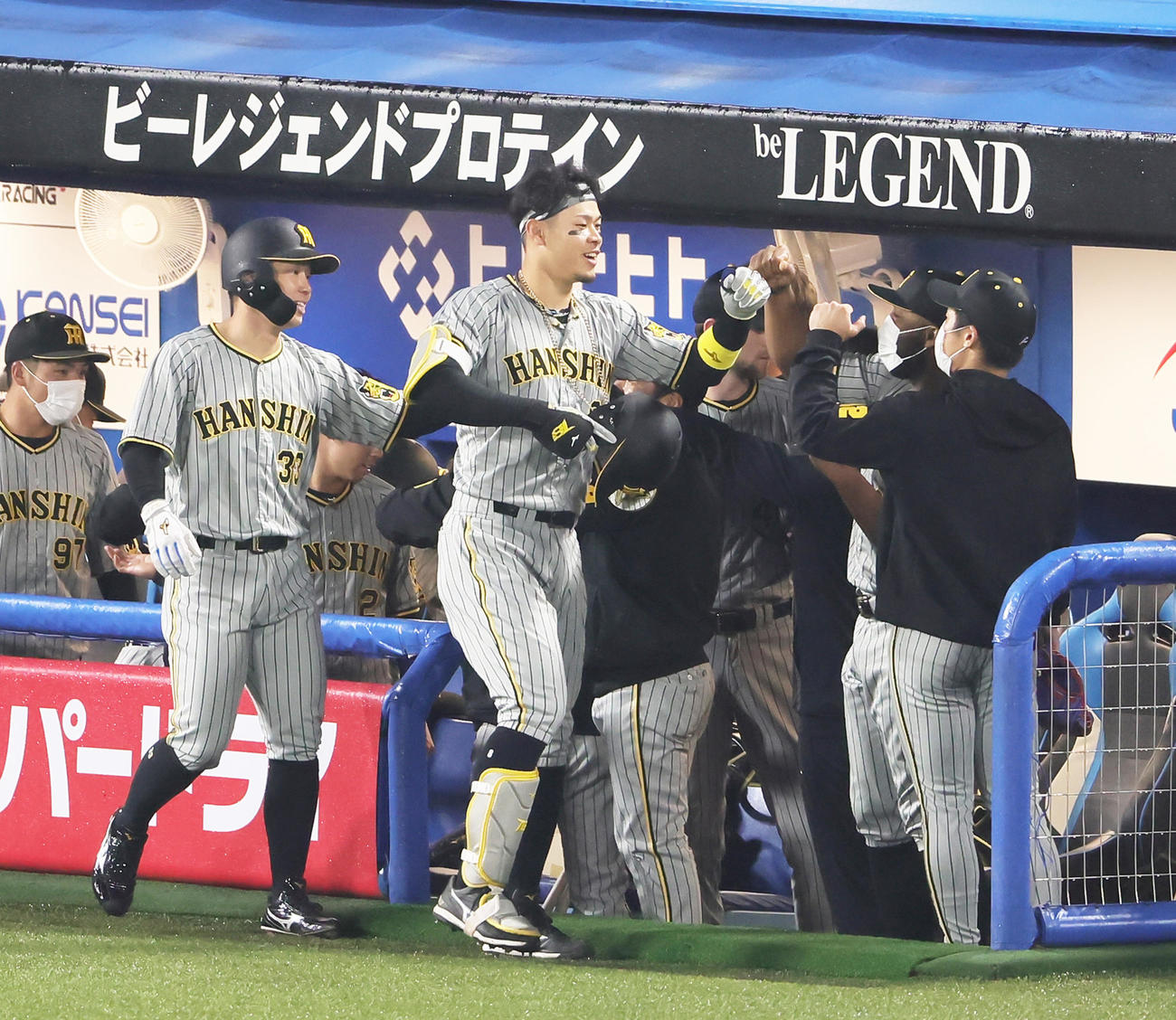 ヤクルト対阪神1回表阪神1死一塁、佐藤輝（中央）は右越え2点本塁打を放ち笑顔でタッチを交わす（撮影・足立雅史）
