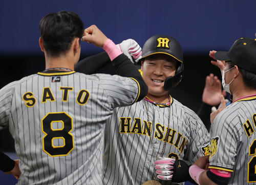中日対阪神　7回表阪神無死一塁、左中間へ同点となる2点本塁打を放ち、佐藤輝（左）らナインに迎えられる大山（中央）（撮影・前田充）