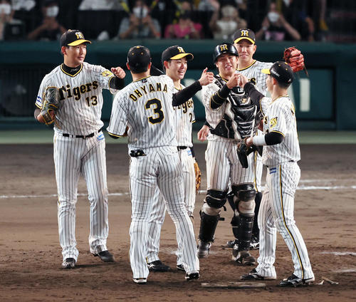 阪神対DeNA　最後を締めた岩崎（左）は笑顔でナインとタッチ（撮影・加藤哉）