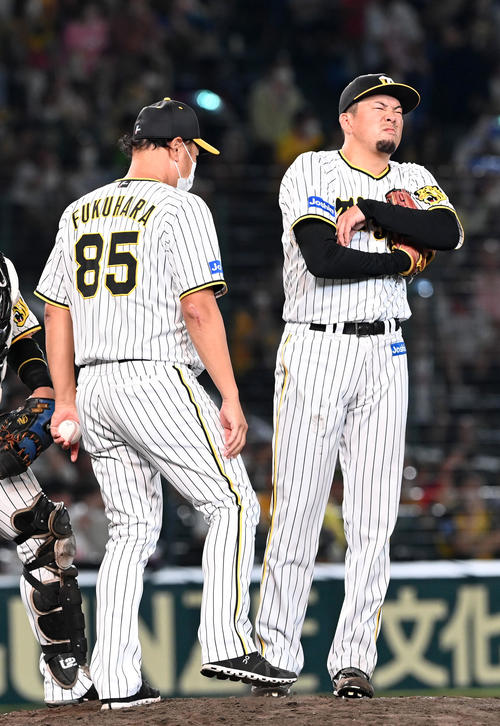 阪神対ヤクルト　7回表ヤクルト無死、村上に左越え本塁打を打たれ交代する渡辺（右）は無念の表情を見せる。左は福原投手コーチ（撮影・前岡正明）