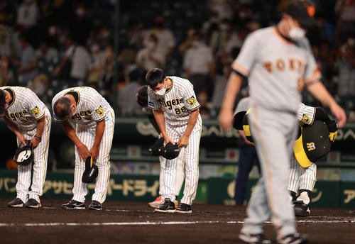 阪神対巨人　12回引き分けとなり原監督（手前）が引き揚げる中、ファンに一礼する矢野監督（中央）（撮影・狩俣裕三）