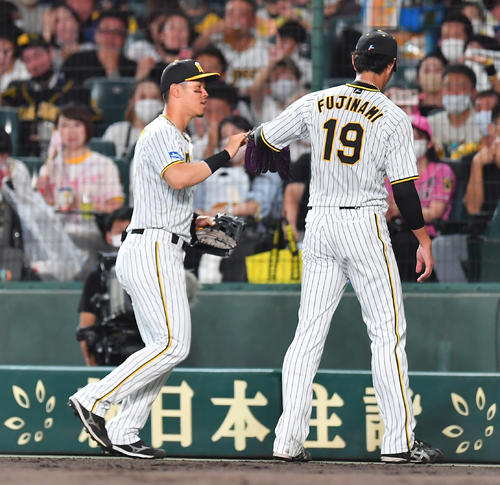 阪神対ヤクルト　2回表、ヤクルト村上の打球を好捕した右翼手佐藤輝（左）とタッチを交わす藤浪（撮影・清水貴仁）
