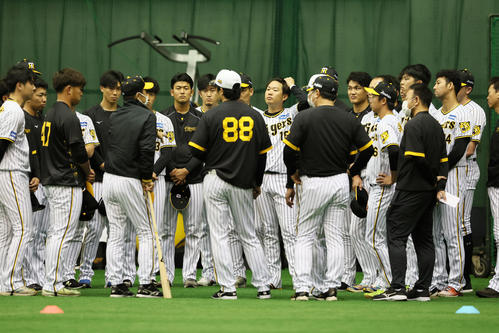 練習開始前、岡田監督（左から5人目）の話を聞く投手陣（撮影・加藤哉）