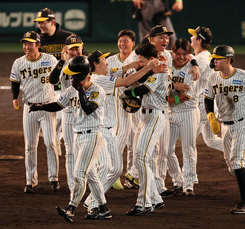 11回裏阪神1死満塁、小幡（右）の中前適時打でサヨナラ勝ちとなり抱き合う湯浅（撮影・加藤哉）