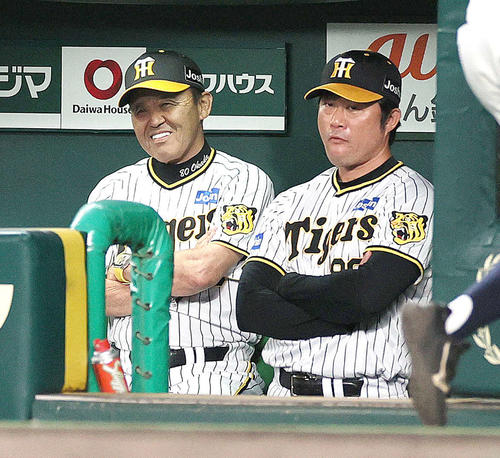 阪神対中日　7回表中日2死二、三塁、伊藤将が代打後藤に中前2点適時打を浴び、腕組みで苦笑いする岡田監督（左）（撮影・上山淳一）