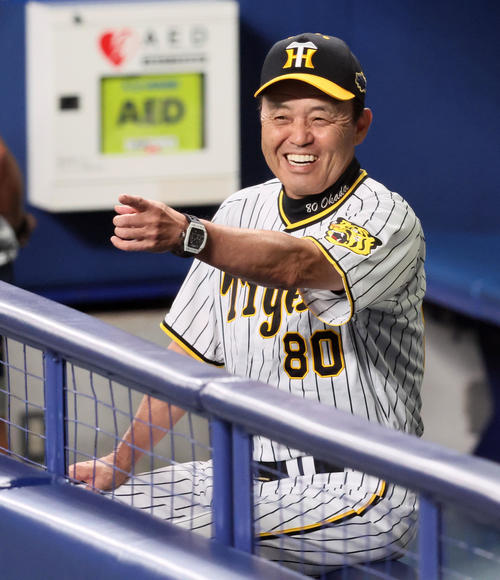 19日、ベンチで笑顔を見せる岡田監督