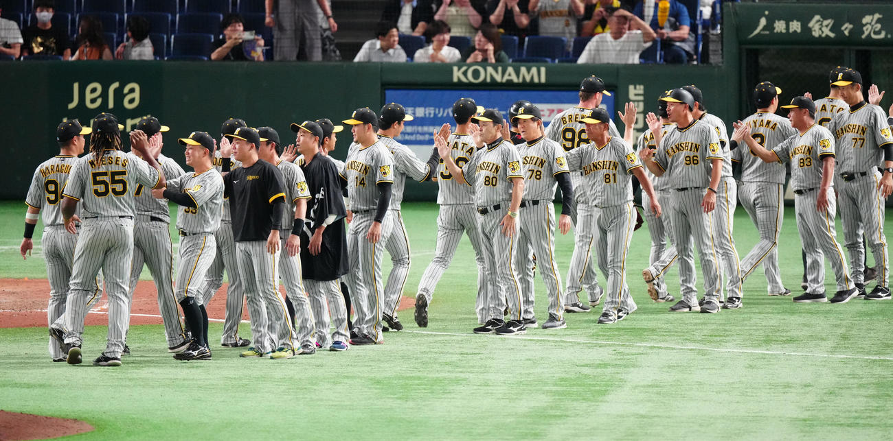 巨人対阪神　巨人に勝利し、選手たちとタッチを交わす阪神岡田監督（中央）（撮影・江口和貴）