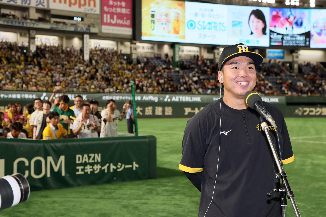 巨人対阪神　阪神ファンを背にヒーローインタビューで笑顔を見せる村上（撮影・加藤哉）