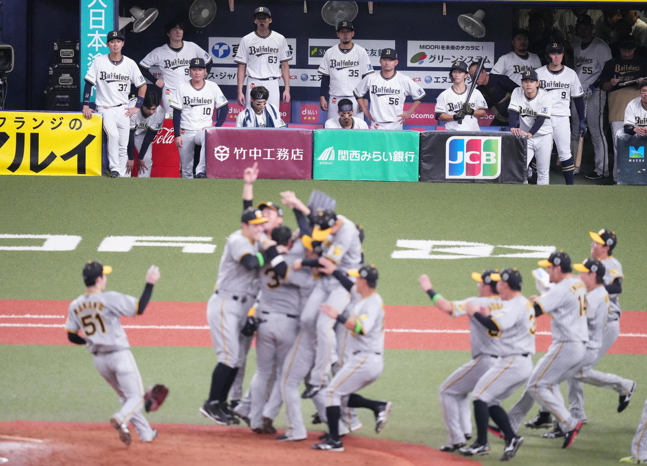 オリックス対阪神　オリックスの選手たち（後方）は日本一に喜びを爆発させる阪神の選手たちを見つめる（撮影・菅敏）
