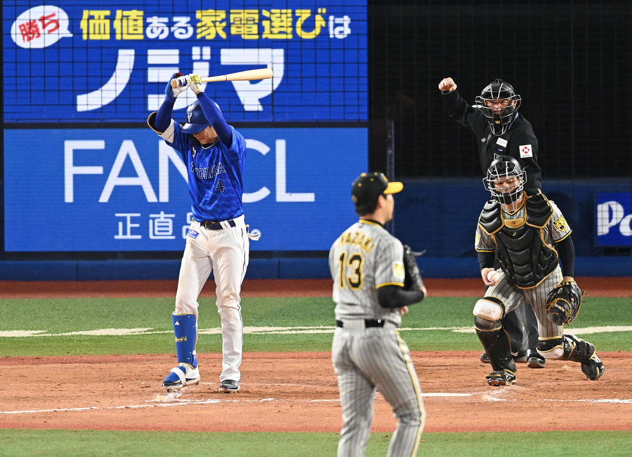 DeNA対阪神　12回裏DeNA2死二、三塁、空振り三振して悔しがる度会（左）。投手岩崎（撮影・山崎安昭）