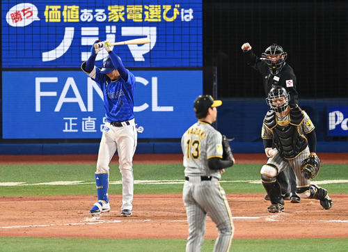 DeNA対阪神　12回裏DeNA2死二、三塁、空振り三振して悔しがる度会（左）。投手岩崎（撮影・山崎安昭）