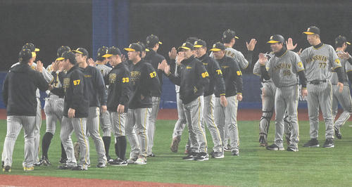 DeNA対阪神　逆転勝ちした阪神岡田監督（中央）はナインをタッチで出迎える（撮影・山崎安昭）