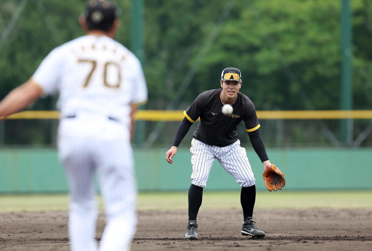 2軍に降格し、ノックを受ける阪神佐藤輝。手前は田中コーチ（撮影・前田充）