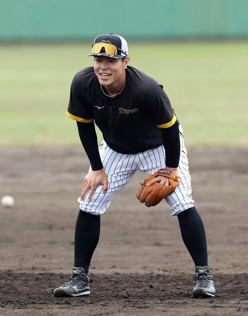 ノックの合間に笑顔を見せる阪神佐藤輝（撮影・前田充）