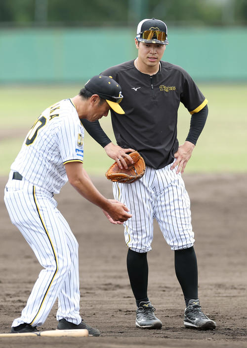 2軍に降格し、阪神田中コーチ（左）から指導を受ける佐藤輝（撮影・前田充）
