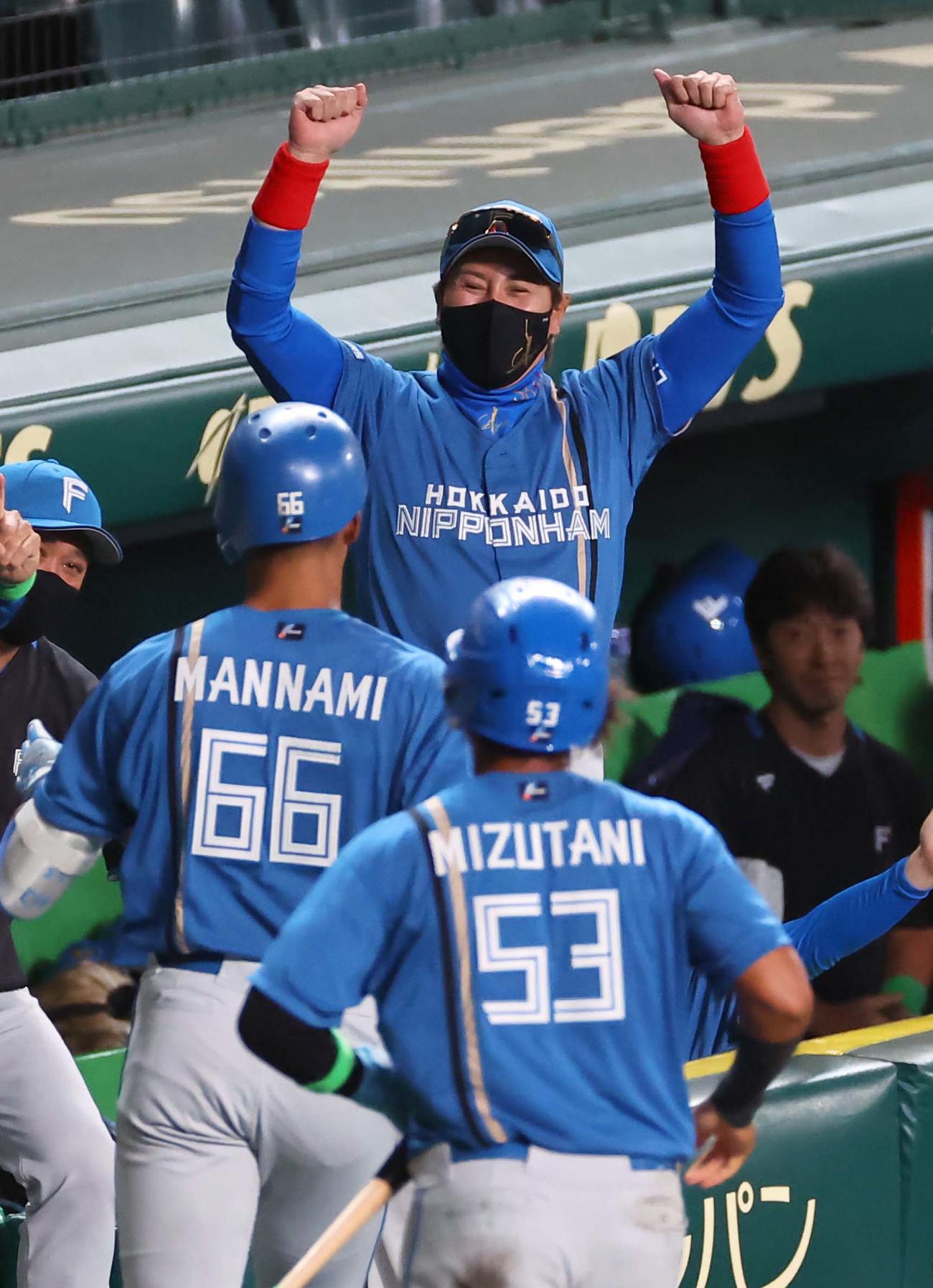 阪神対日本ハム　5回表日本ハム2死一塁、左越え2点本塁打を放った万波（左）を笑顔で出迎える新庄監督（撮影・上田博志）
