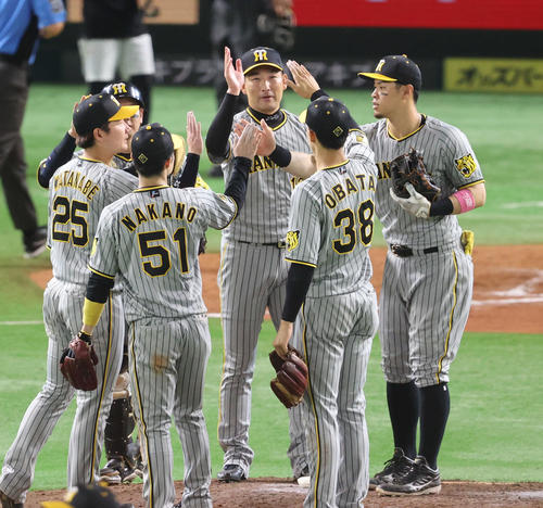 ソフトバンク対阪神　ソフトバンクに勝利した阪神ナインはハイタッチをかわす（撮影・梅根麻紀）