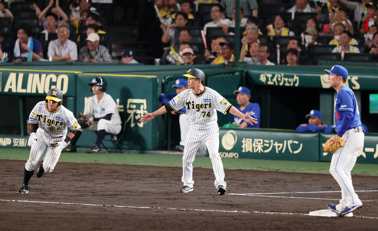 阪神対中日　9回裏阪神1死一塁、前川の右二塁打で一走植田（左）を三塁で止めた藤本コーチ（撮影・加藤哉）