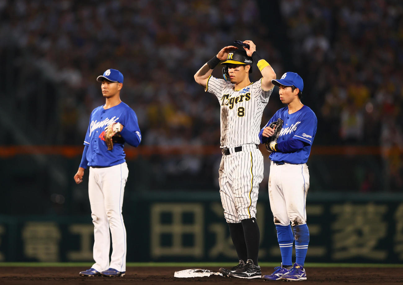 阪神対中日　5回裏阪神1死、リクエストも判定が変わらず頭を抱える佐藤輝。右は二塁手田中（撮影・上山淳一）