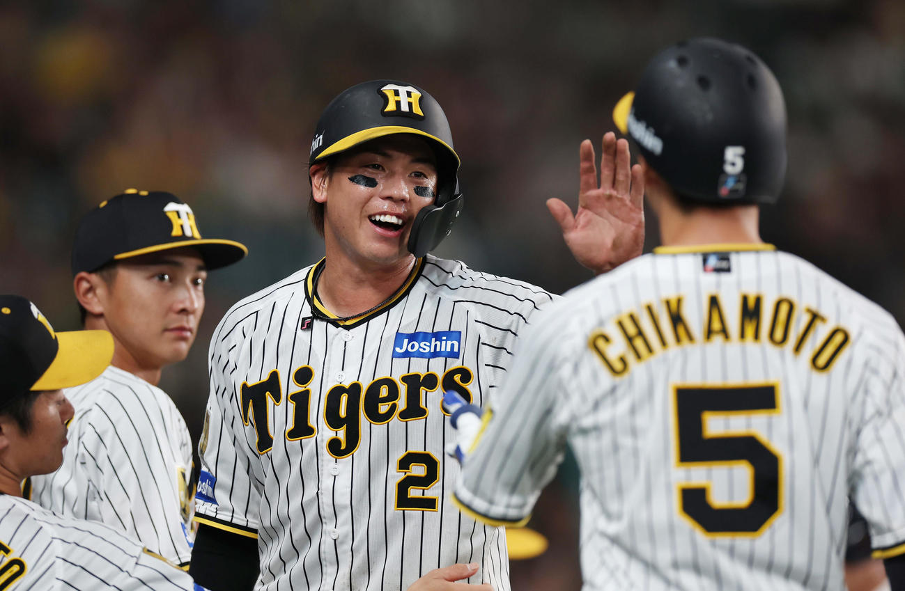 阪神対DeNA 7回裏阪神1死一、三塁、同点の生還を果たし、犠飛を放った近本（右）とタッチを交わす梅野（中央）（撮影・前田充）