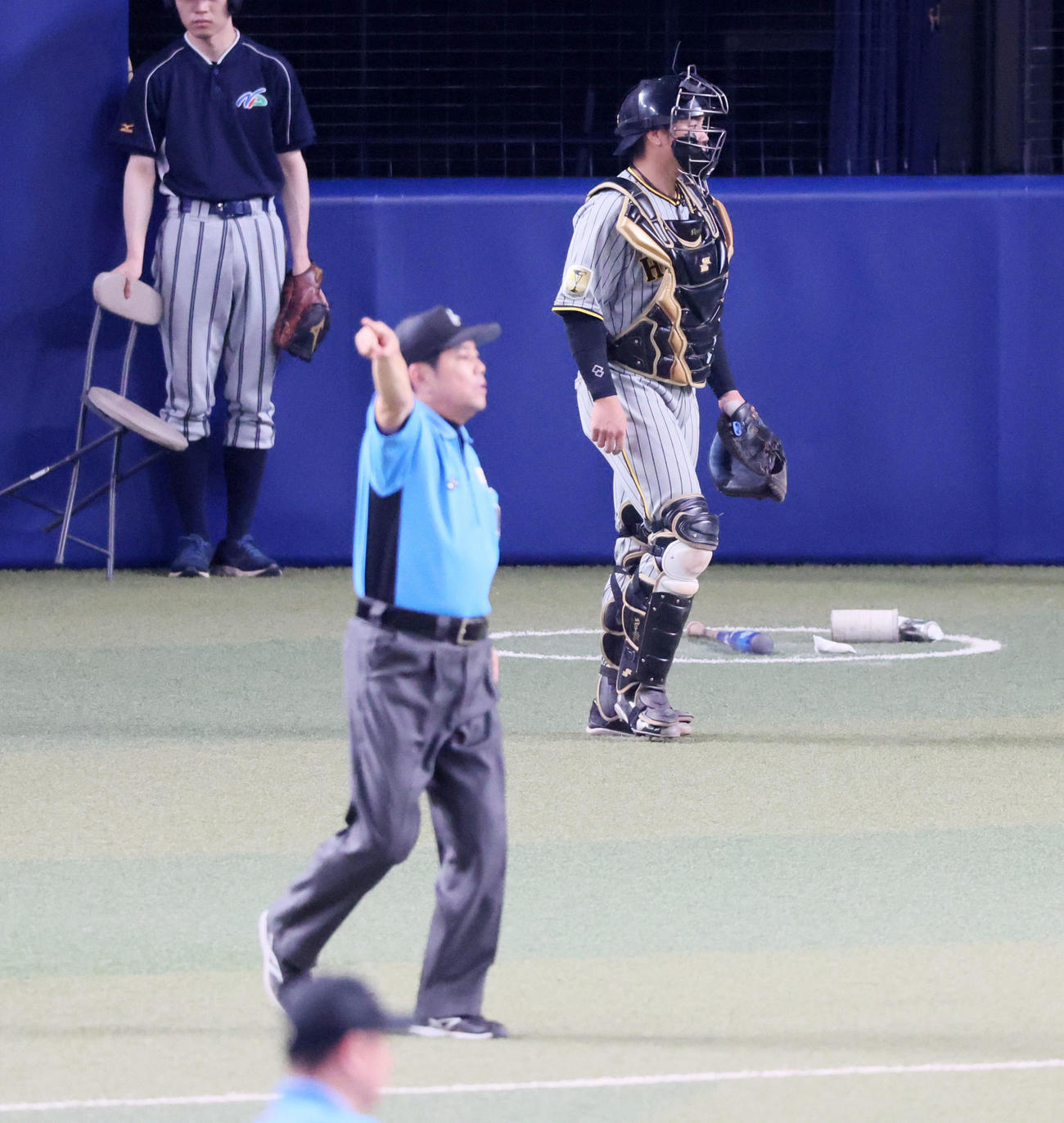 中日対阪神　8回裏中日1死一塁、梅野はゲラの暴投でボールを捕りに行ったがベンチに入ったため本塁へ引き揚げる。手前は一塁走者高橋周に二塁へ戻るよう促す審判員（撮影・加藤哉）