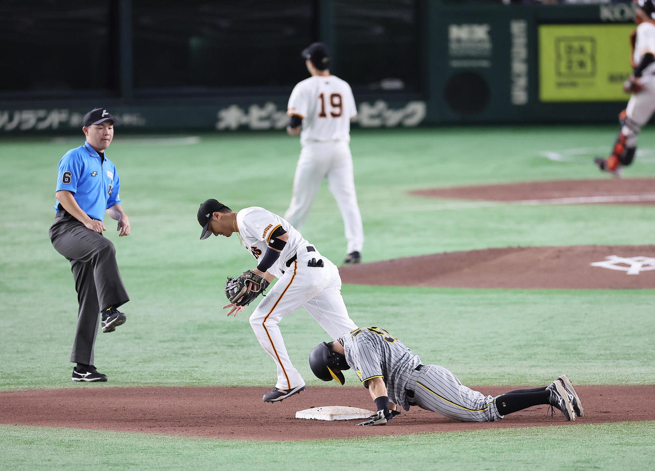 巨人対阪神　5回表阪神2死一、二塁、山崎伊（後方）の二塁けん制に戻りきれずアウトとなる野口（右）。二塁手吉川（撮影・足立雅史）