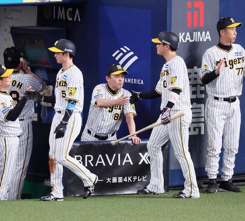 阪神対ヤクルト　8回裏阪神2死一、三塁、中野の右適時二塁打で生還した近本（左）と木浪を出迎える岡田監督（撮影・加藤哉）