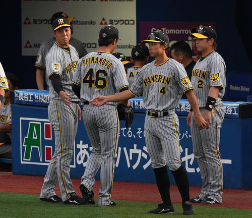 DeNA対阪神　5回裏終了後、ベンチへ戻る阪神島本（左から2人目）を労う青柳（左）（撮影・横山健太）