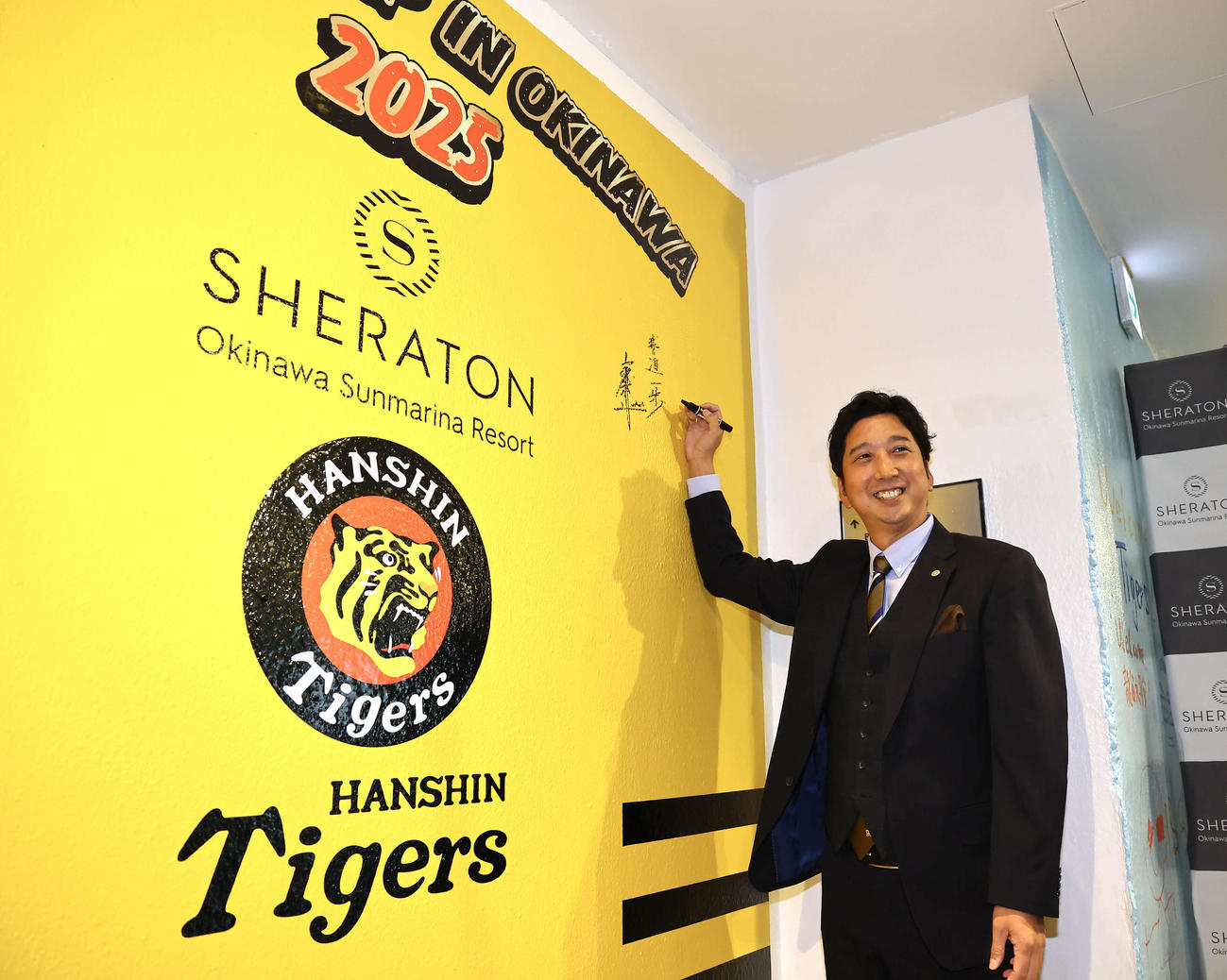 キャンプ地の沖縄に到着し、宿舎の壁画にサインを入れる阪神藤川監督（撮影・藤尾明華）