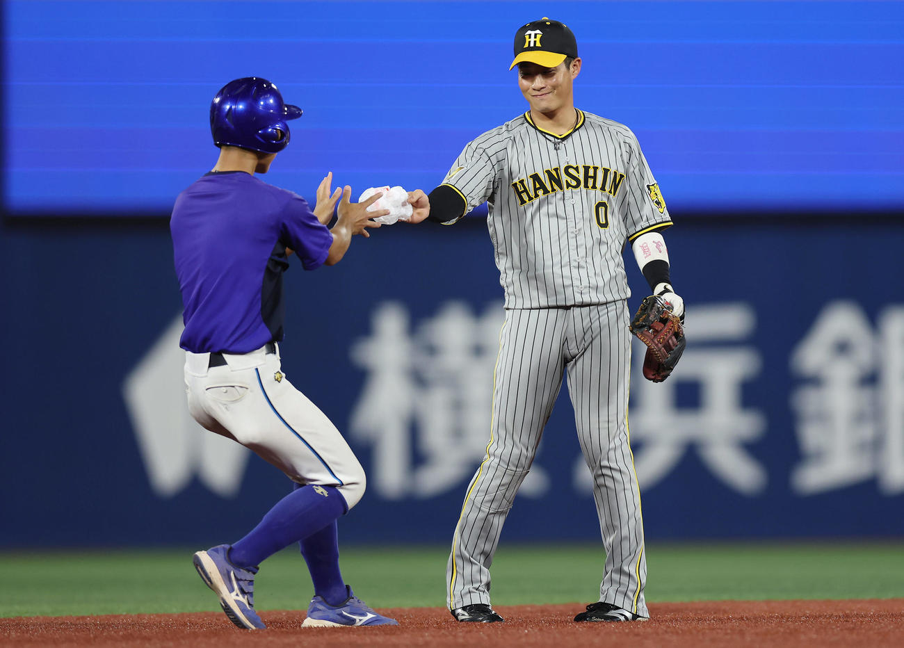 2024年9月20日、グラウンドに飛んできたポリ袋を拾い、球場スタッフに渡す阪神木浪（2024年9月20日撮影）