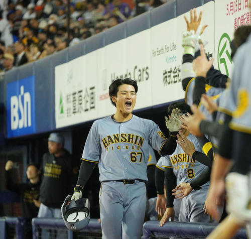 DeNA対阪神　9回表阪神2死、右越えソロ本塁打を放ちナインの出迎えを受ける高寺（撮影・垰建太）