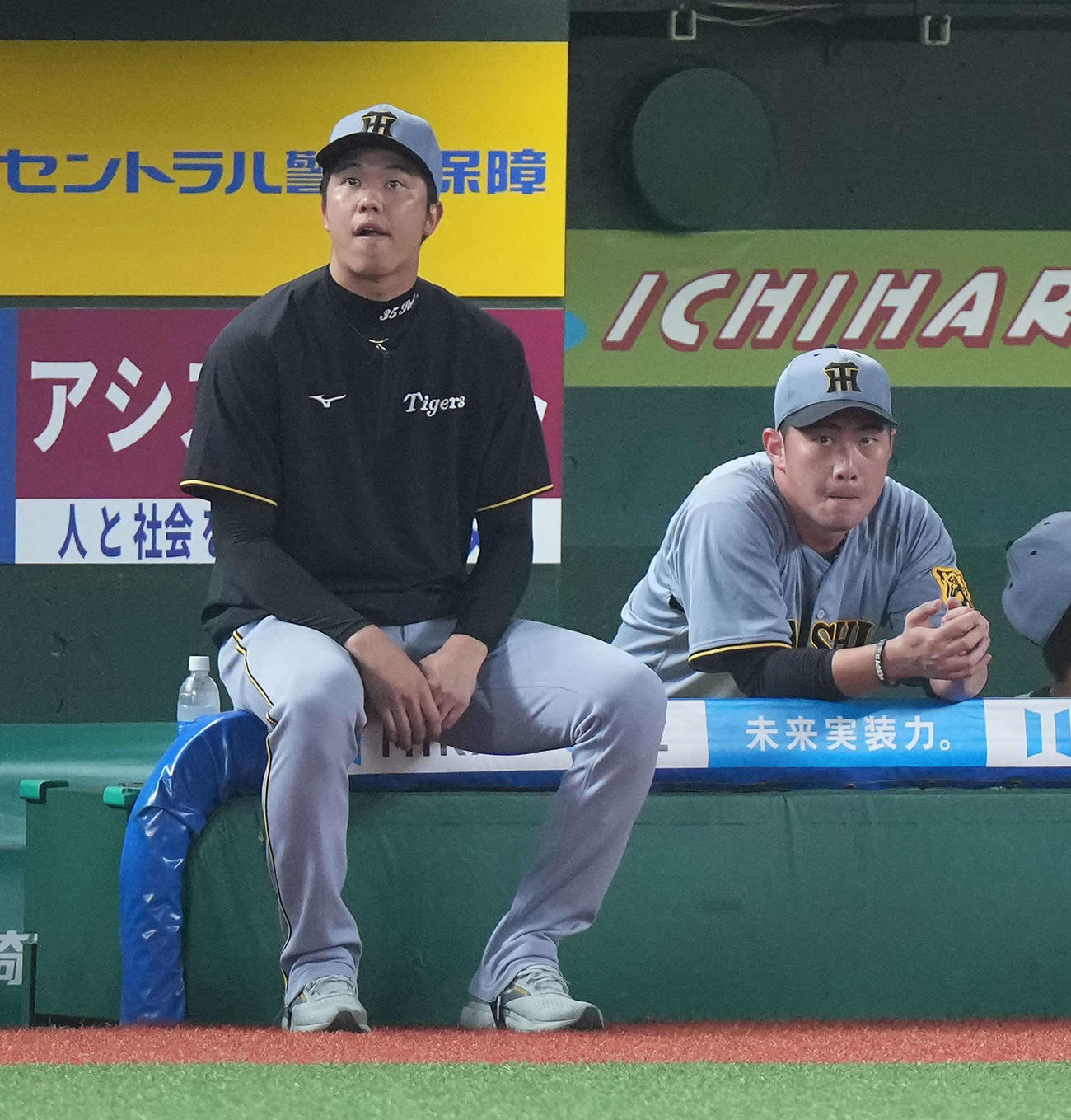 西武対阪神　8回裏、西武に勝ち越しを許しベンチに下がった桐敷拓（右）は、先発の才木と厳しい表情を見せる（撮影・たえ見朱実）