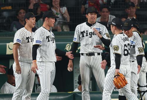阪神対巨人　8回を無失点に抑えた石井（右から2人目）を出迎える湯浅、及川、才木（撮影・上田博志）