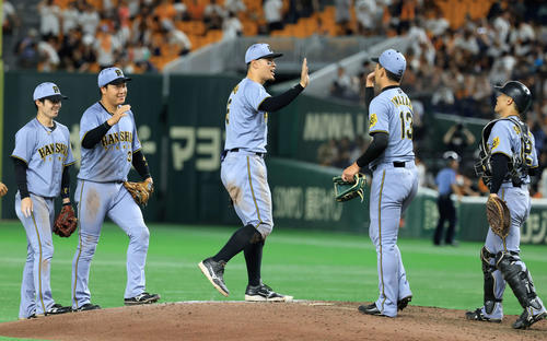 巨人対阪神　延長戦の末に勝利し、笑顔でハイタッチする佐藤輝（中央）ら阪神の選手たち（撮影・浅見桂子）