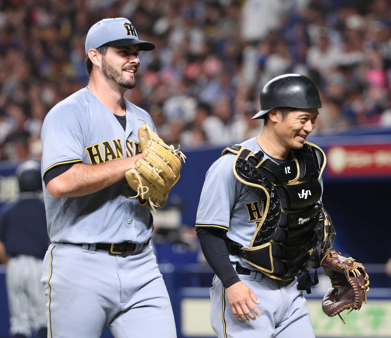中日対阪神　来日初登板の阪神2番手ハートウィグはいきなり3連続四球を出したものの無失点で切り抜け笑顔でベンチに戻る。右は坂本（撮影・西尾就之）
