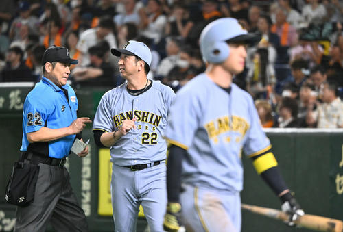 巨人対阪神　8回裏、交代を伝える阪神藤川監督。手前は空振り三振に倒れた近本（撮影・滝沢徹郎）