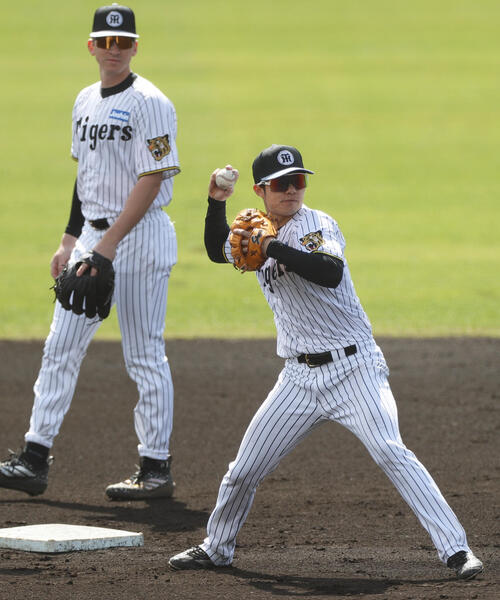 シートノックで送球する阪神中野（手前）とディベイニー（2026年2月18日撮影）