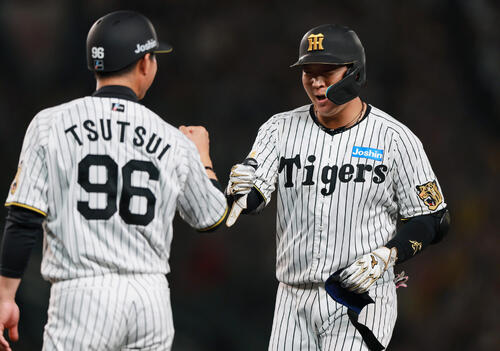 阪神対中日　6回裏阪神無死三塁、大山（右）は適時打を放ち筒井外野守備兼走塁チーフコーチとタッチをかわす（撮影・上山淳一）