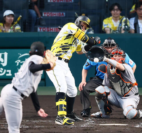 阪神対巨人　3回裏阪神1死一塁、死球を受ける佐藤輝明。投手竹丸和幸（撮影・加藤哉）
