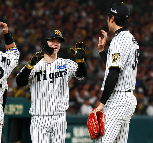 阪神対DeNA 3回裏阪神2死満塁、三走中野拓夢は元山飛優の一塁への2点適時内野安打で生還しベンチのナインとタッチする（撮影・加藤哉）