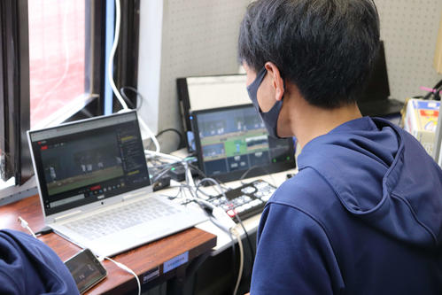 日体大対亜大　グラウンドの本部席からオープン戦の動画画面の切り換え操作をする日体大・大塚（撮影・保坂淑子）