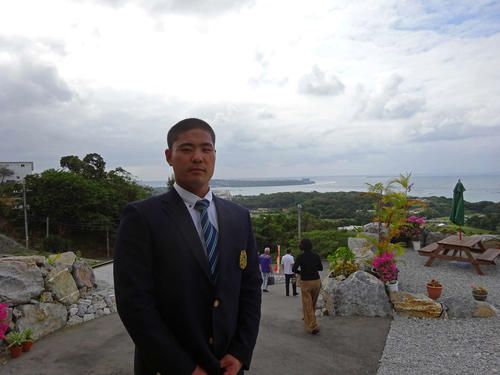 故郷の本部町の町役場を表敬訪問した楽天内間。山の上から本部町を見渡す（内間後援会・提供）