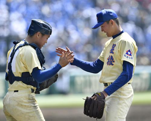 富島を破り、タッチを交わす星稜の奥川（右）と捕手山瀬（共同）