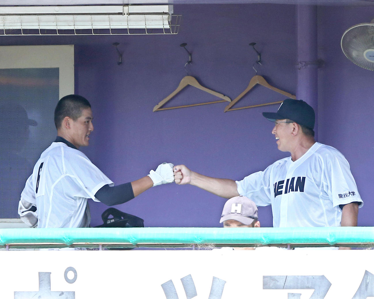 龍谷大平安対乙訓　４回表龍谷大平安１死満塁、松田（左）は中犠飛を放ちベンチで原田監督と笑顔でグータッチ（撮影・上山淳一）