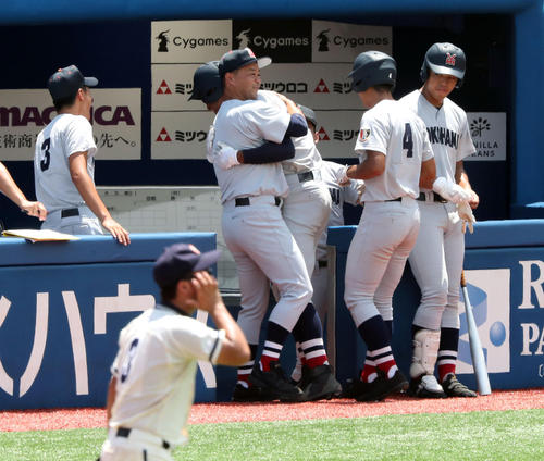 横浜対鎌倉学園　３回表横浜無死二塁、特大の２点本塁打を放ちベンチに戻った万波を抱擁する平田監督（撮影・宇治久裕）