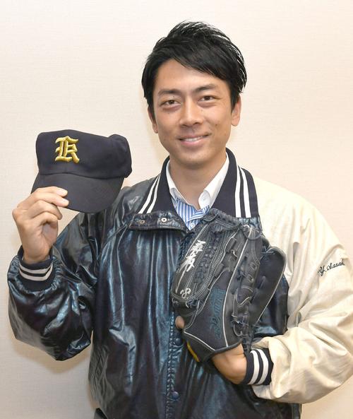 高校時代のウインドブレーカーを着て、笑顔を見せる小泉進次郎議員。グラブには三浦大輔氏のサインが書いてあった（撮影・酒井清司）