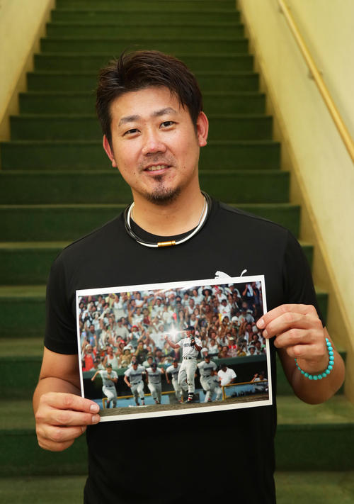 第８０回夏の甲子園で優勝を決めた瞬間の写真を手に笑顔の中日松坂（撮影・足立雅史）