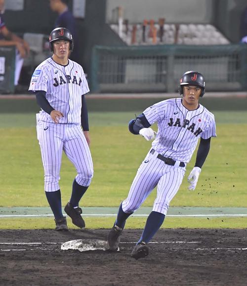 香港対日本代表　2回裏日本代表2死二塁、中前打を放った根尾。左は一塁コーチ吉田（撮影・上田博志）